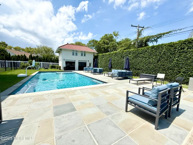 a swimming pool with outdoor seating and yard