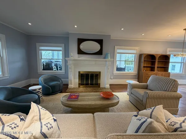 a living room with furniture large window and wooden floor