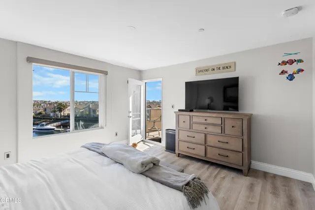 a bed room with a bed television and a window