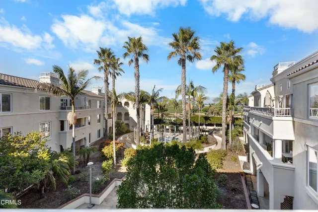 a view of a white house with a yard and potted plants