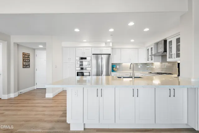 a kitchen with stainless steel appliances granite countertop a refrigerator and a sink