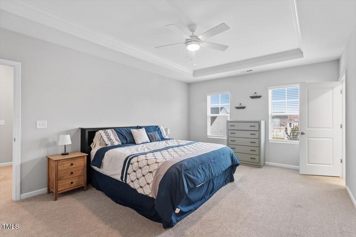 320 Everly Mist Way Wake Forest, NC 27587 - Photo 11 of 34 a spacious bedroom with a bed a table and closet