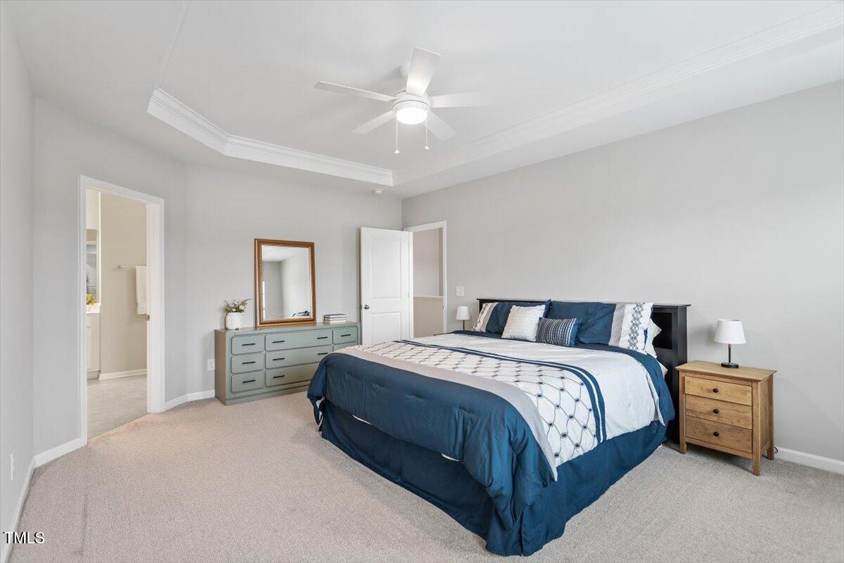 320 Everly Mist Way Wake Forest, NC 27587 - Photo 13 of 34 a spacious bedroom with a bed and a chandelier