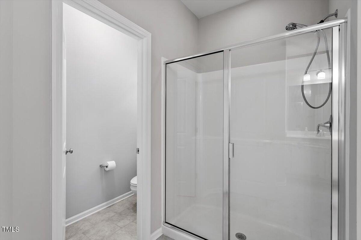 320 Everly Mist Way Wake Forest, NC 27587 - Photo 15 of 34 a bathroom with a glass shower door