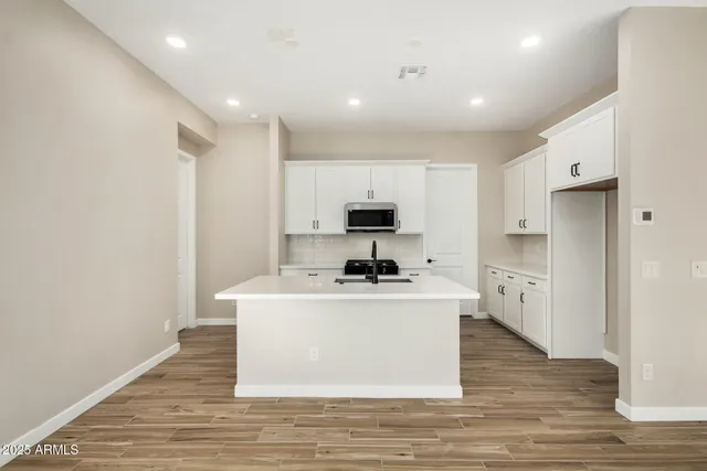 a kitchen with a sink a microwave a refrigerator and cabinets
