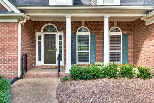 a front view of a house with glass windows and a yard