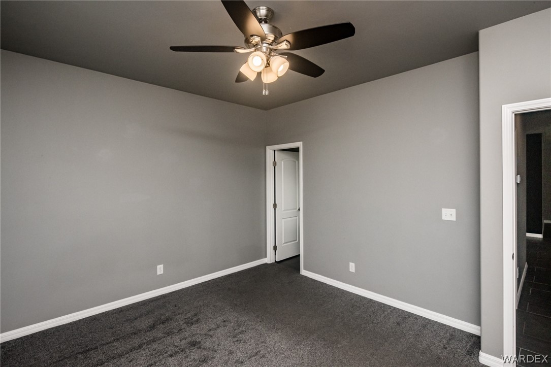 3621 North Kenneth Road Kingman, AZ 86409 - Photo 25 of 47 an empty room with closet and a chandelier fan
