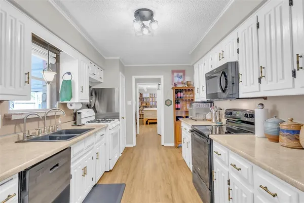 a kitchen with stainless steel appliances granite countertop a lot of counter space and wooden floors