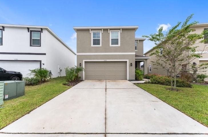30753 Penny Surf Loop Wesley Chapel, FL 33545 - Photo 1 of 1 a front view of a house with a yard and a garage