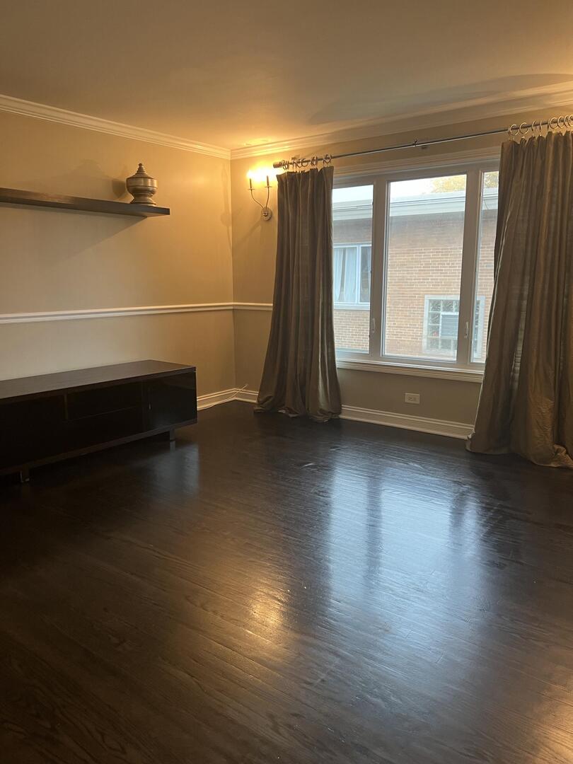 9121 Niles Center Road, Unit 2W Skokie, IL 60076 - Photo 6 of 12 an empty room with wooden floor and windows