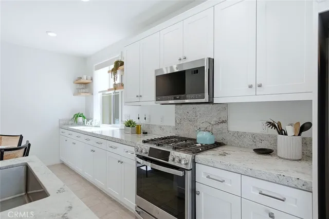 a kitchen with white cabinets and a stove top oven