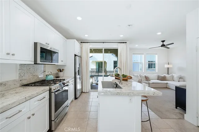 a kitchen with a refrigerator a stove a sink and chairs
