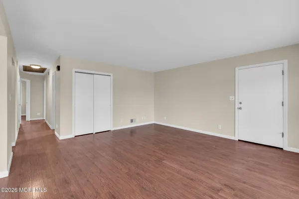 a view of an empty room with wooden floor