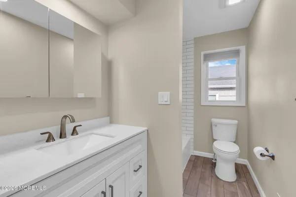 a bathroom with a toilet a sink and mirror