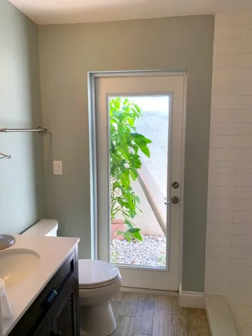 a bathroom with a granite countertop sink and a toilet