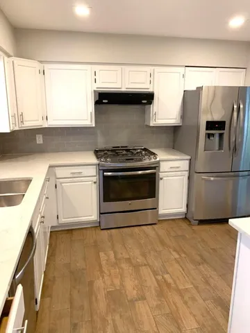 a kitchen with granite countertop a sink stove and refrigerator