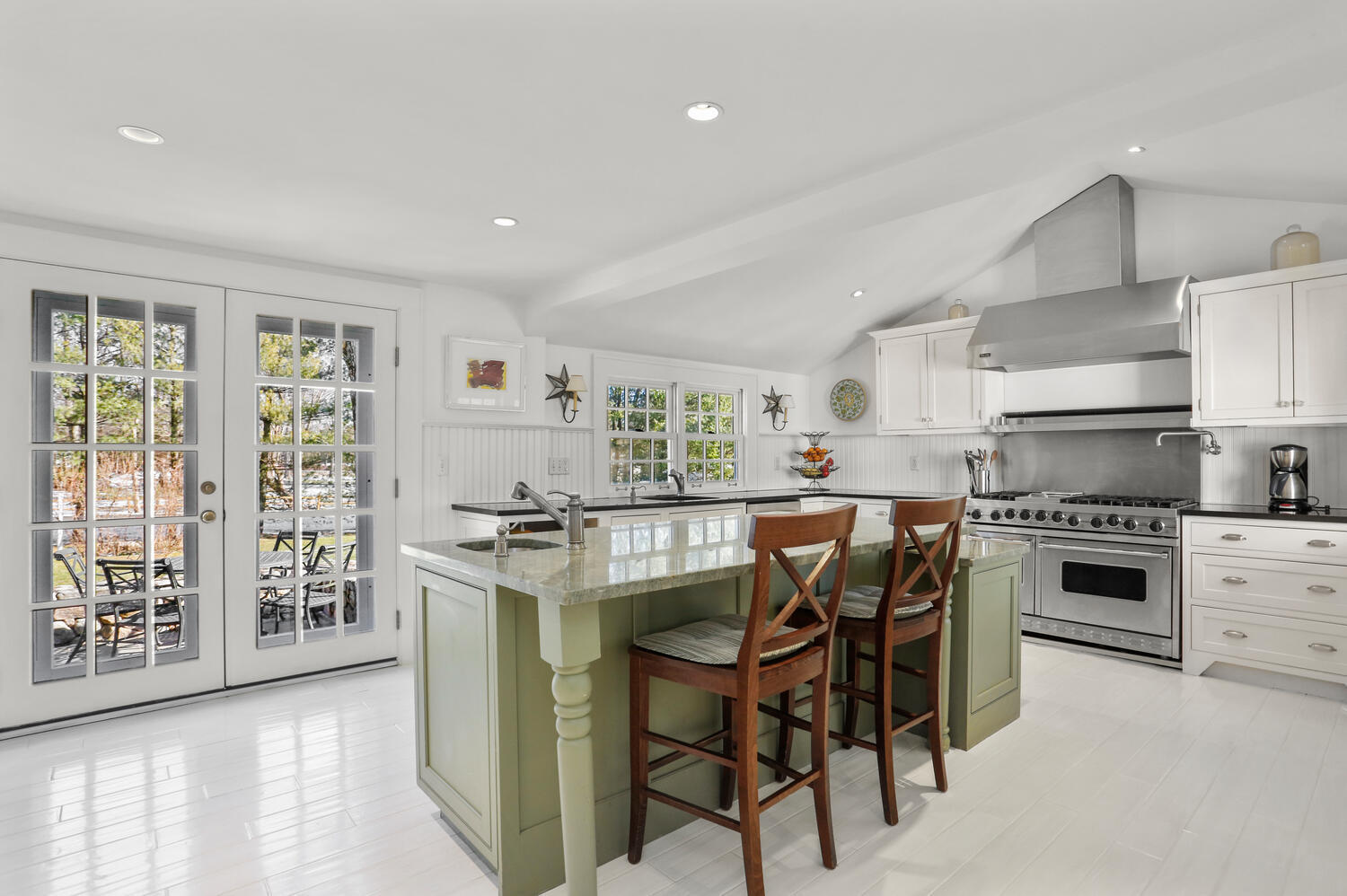427 Eden Road Stamford, CT 06907 - Photo 3 of 40 a kitchen with stainless steel appliances granite countertop a stove top oven a refrigerator a stove with island chairs and wooden floor