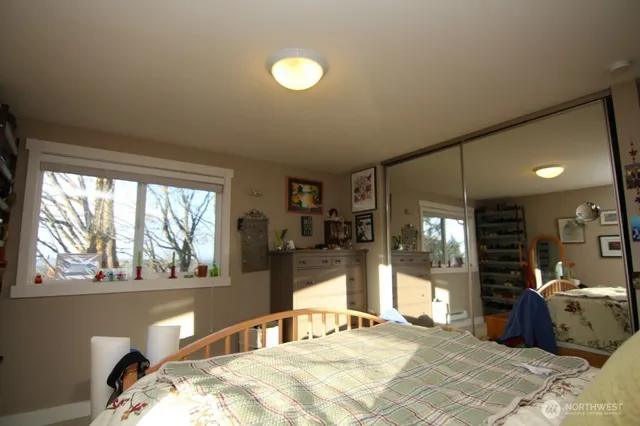 a bedroom with a bed and large windows