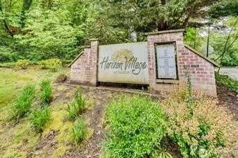 a sign of golf club on a wall under a tree