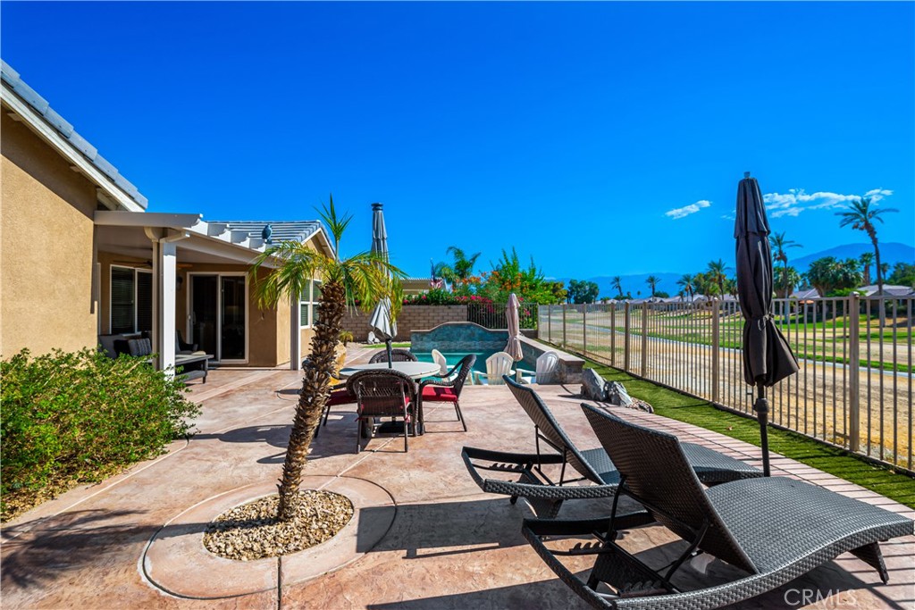 49267 Biery Street Indio, CA 92201 - Photo 18 of 28 a view of a patio with a dining table and chairs with wooden floor