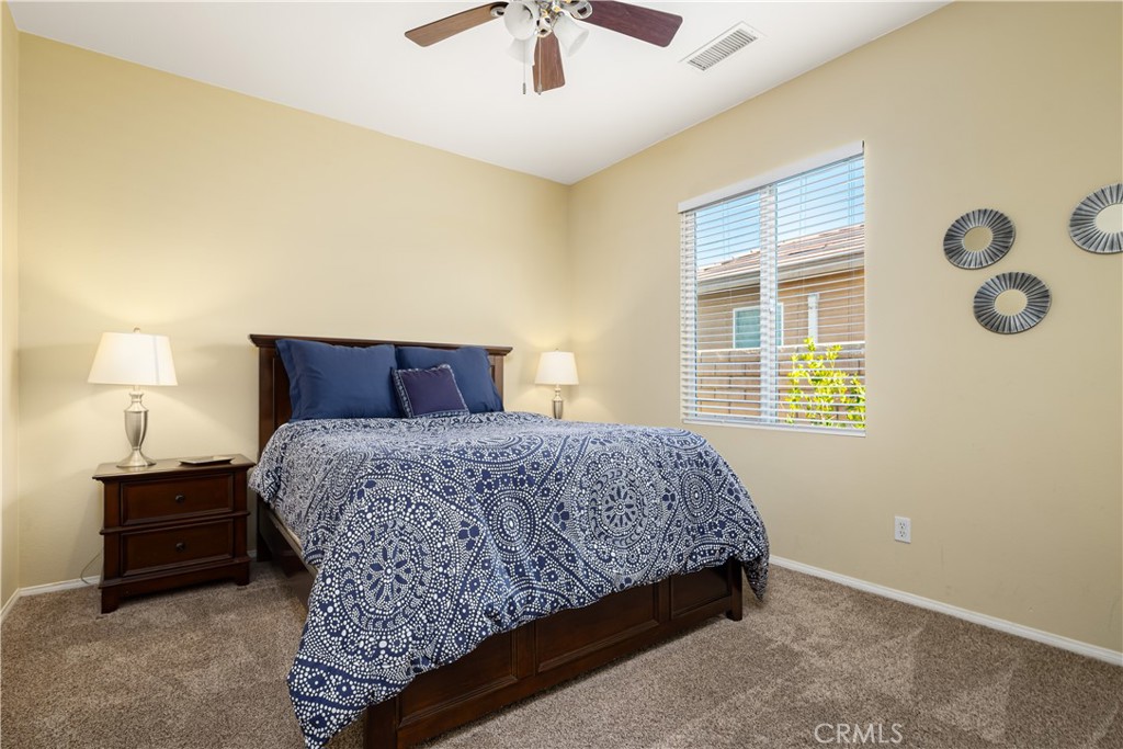 49267 Biery Street Indio, CA 92201 - Photo 21 of 28 a bedroom with a bed and a chandelier