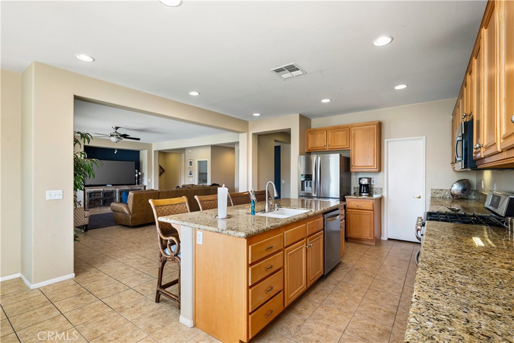 49267 Biery Street Indio, CA 92201 - Photo 8 of 28 a large kitchen with kitchen island a large counter top furniture and a view of living room