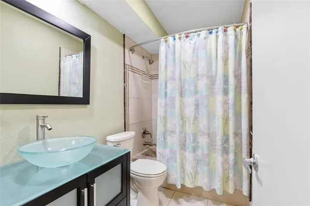a bathroom with a granite countertop sink toilet and a mirror