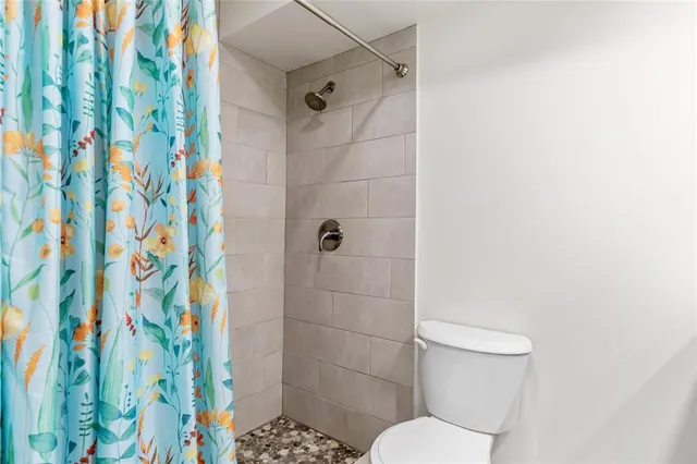 a white toilet sitting next to a shower curtain