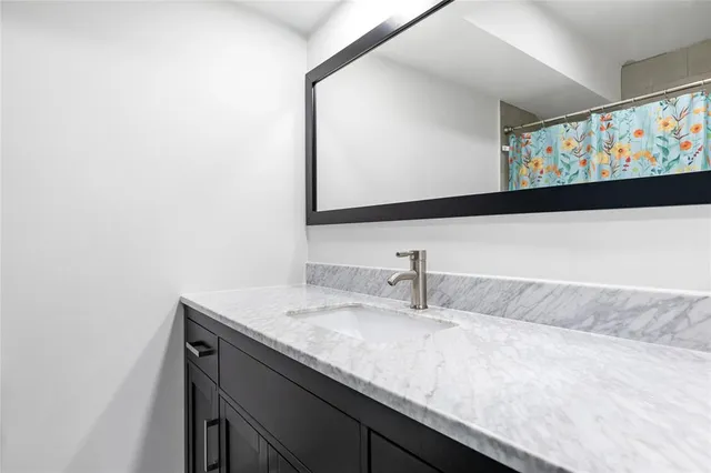 a bathroom with a granite countertop sink and a mirror