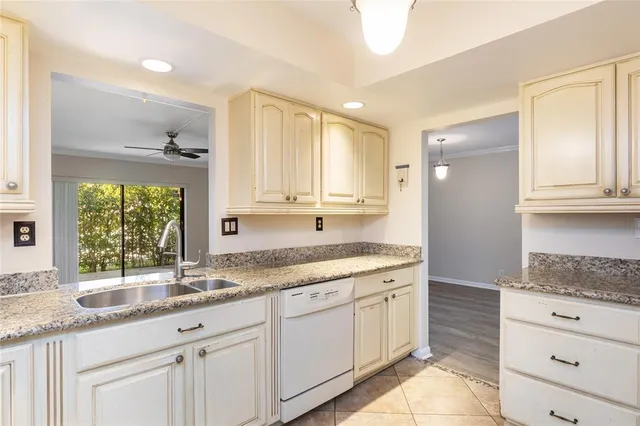 a kitchen with granite countertop white cabinets and a window