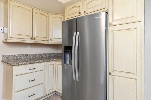 a kitchen with granite countertop cabinets and refrigerator