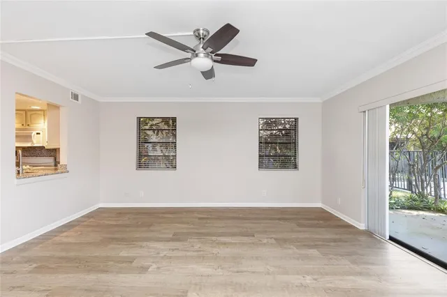 a view of a big room with wooden floor and windows