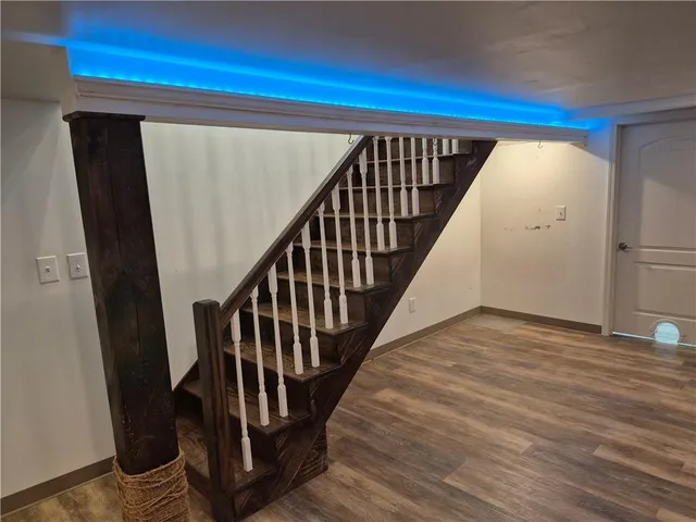 a view of a hallway with wooden floor and staircase