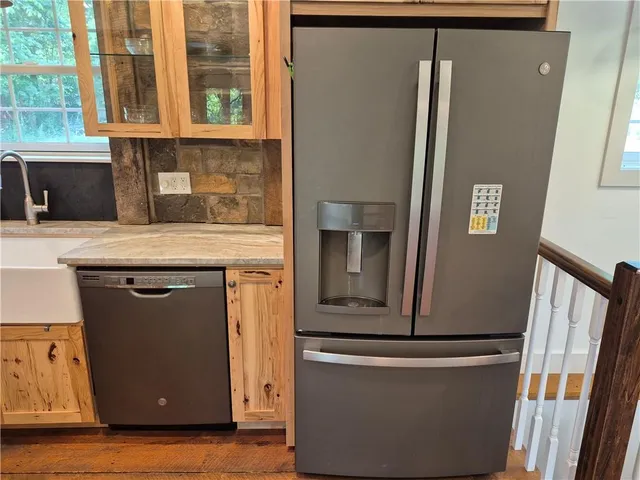 a view of kitchen with stainless steel appliances granite countertop cabinets and a refrigerator