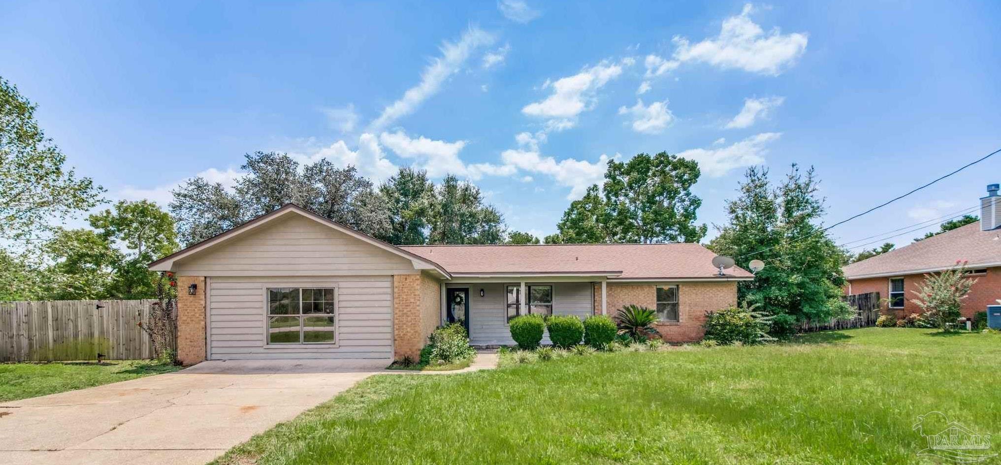 7489 Sandstone Street Navarre, FL 32566 - Photo 1 of 49 a front view of a house with a garden
