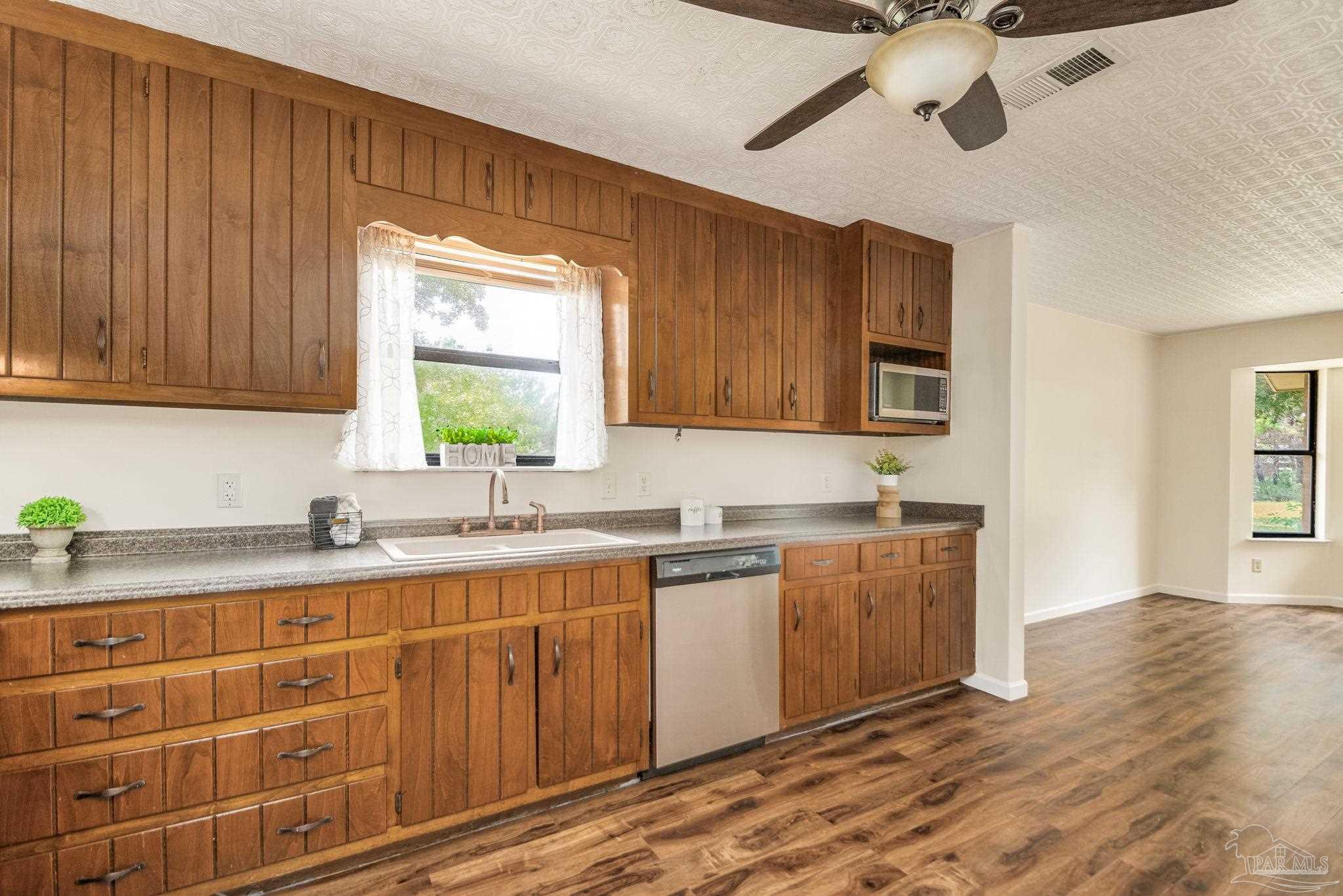 7489 Sandstone Street Navarre, FL 32566 - Photo 12 of 49 a kitchen with stainless steel appliances granite countertop a sink a stove cabinets and wooden floor