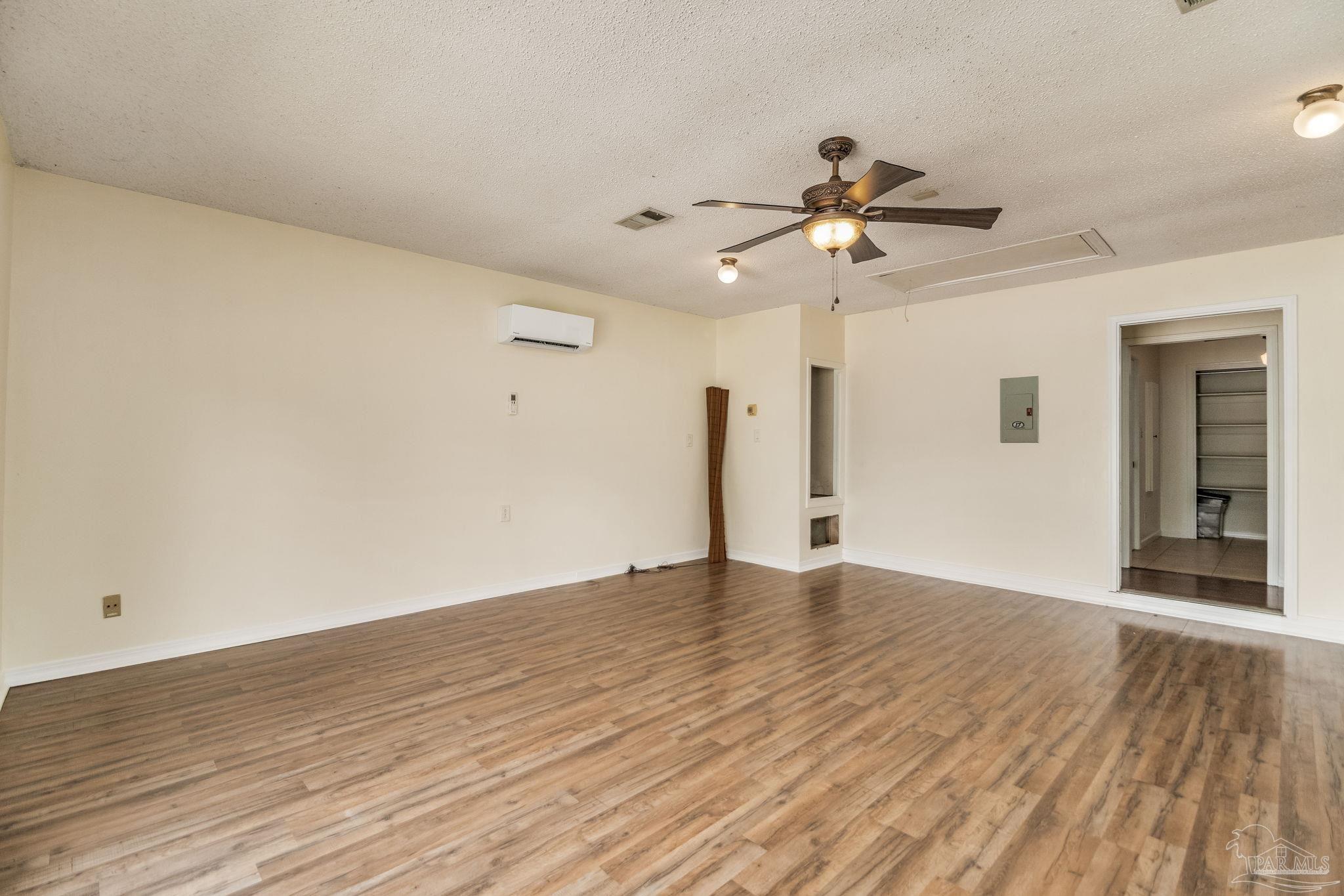 7489 Sandstone Street Navarre, FL 32566 - Photo 16 of 49 a view of an empty room with window and wooden floor
