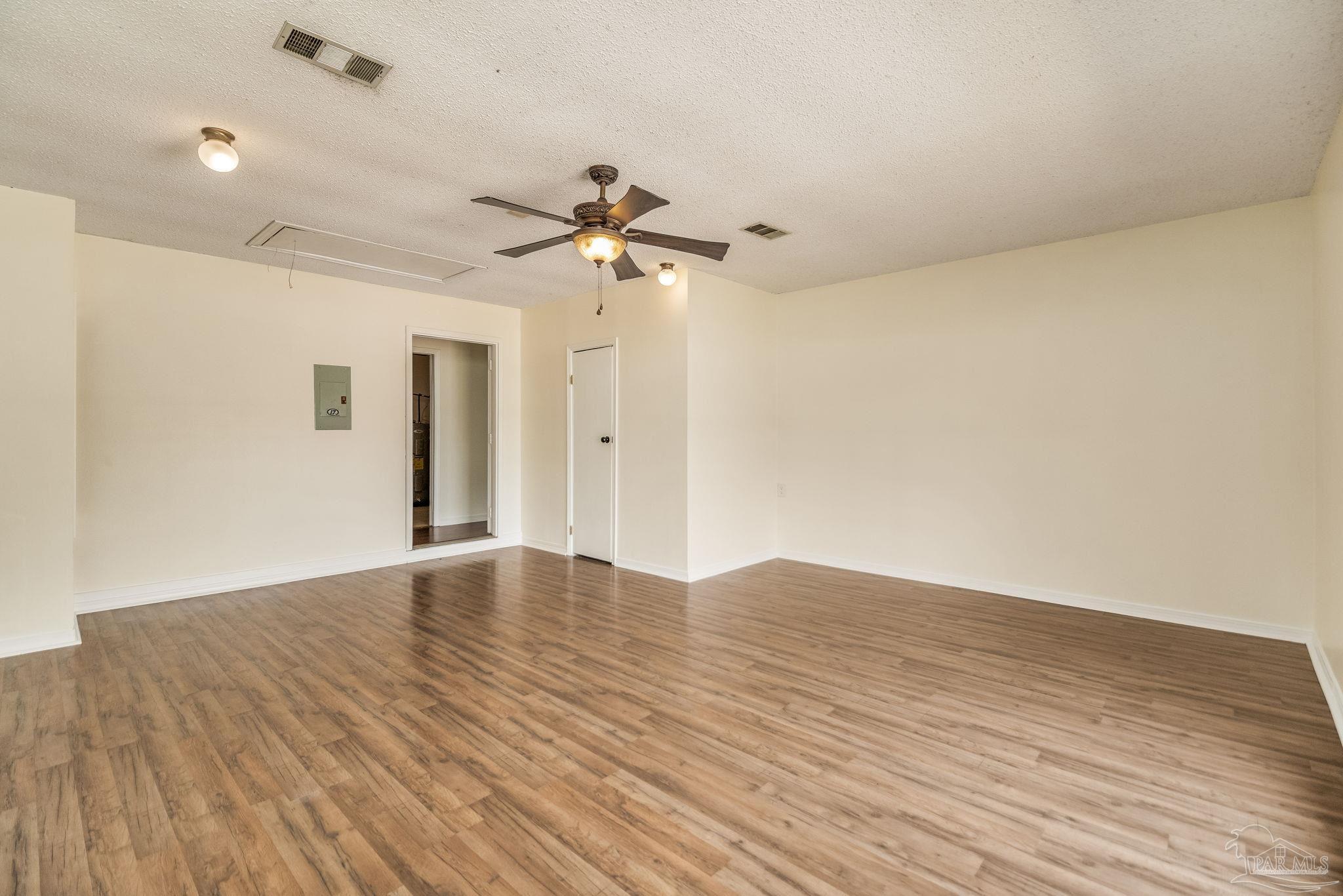 7489 Sandstone Street Navarre, FL 32566 - Photo 17 of 49 a view of empty room with wooden floor and fan