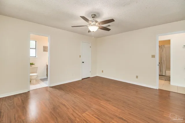 a view of a livingroom with a ceiling fan and wooden floor