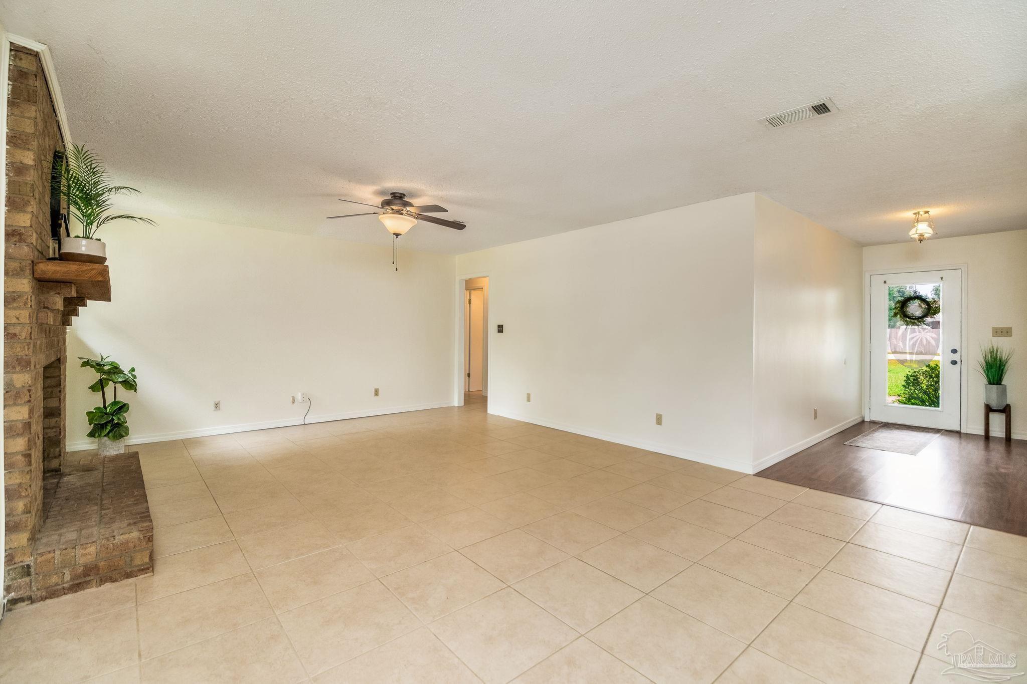 7489 Sandstone Street Navarre, FL 32566 - Photo 2 of 49 wooden floor in an empty room