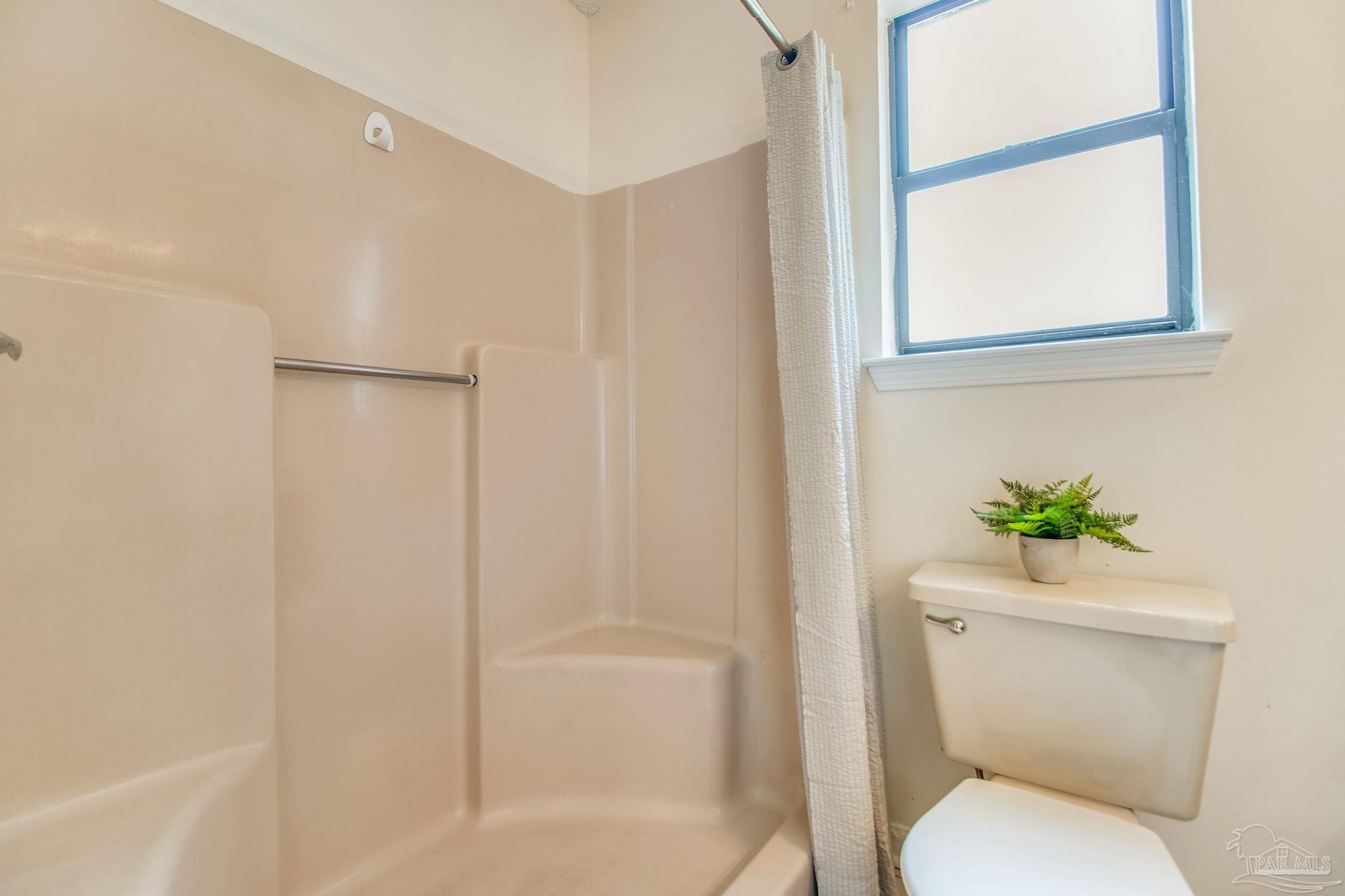 7489 Sandstone Street Navarre, FL 32566 - Photo 24 of 49 a white toilet sitting next to a bathroom sink