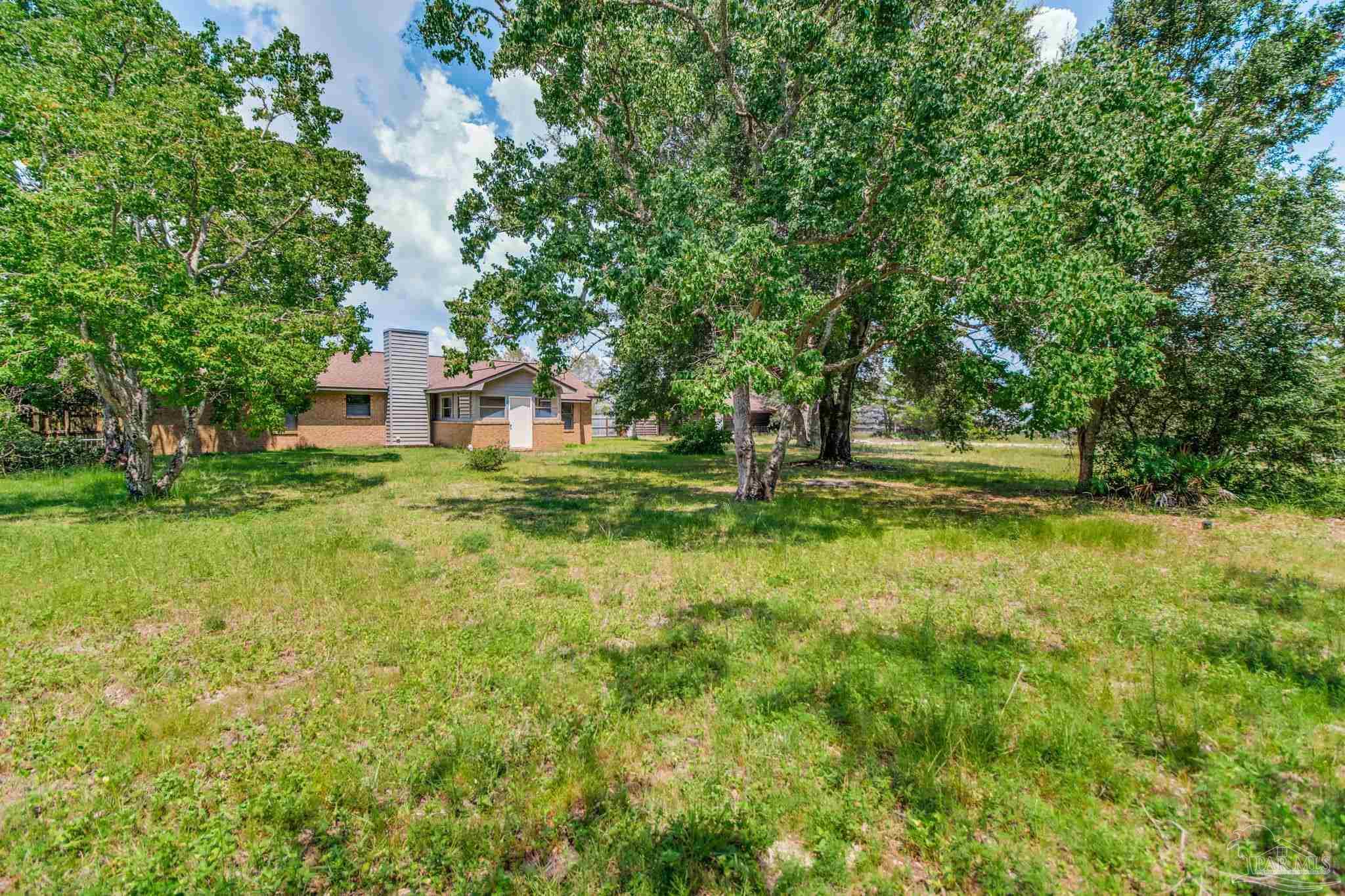 7489 Sandstone Street Navarre, FL 32566 - Photo 34 of 49 a backyard of a house with lots of green space and fountain