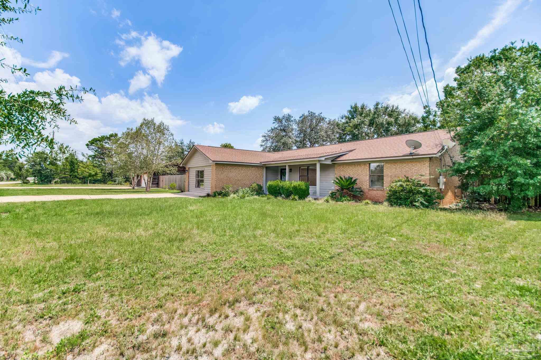 7489 Sandstone Street Navarre, FL 32566 - Photo 38 of 49 a front view of a house with garden