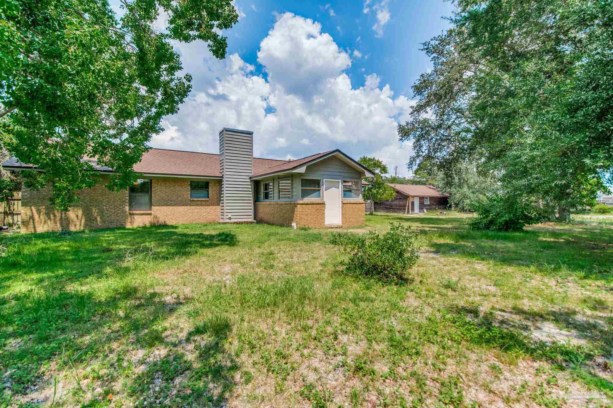 7489 Sandstone Street Navarre, FL 32566 - Photo 4 of 49 a front view of a house with garden