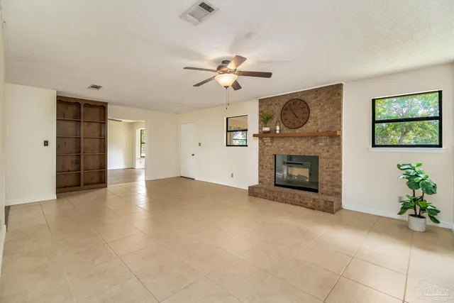 an empty room with windows and fireplace