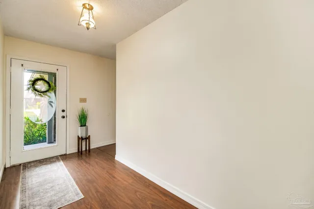 a view of a hallway with wooden floor and a window