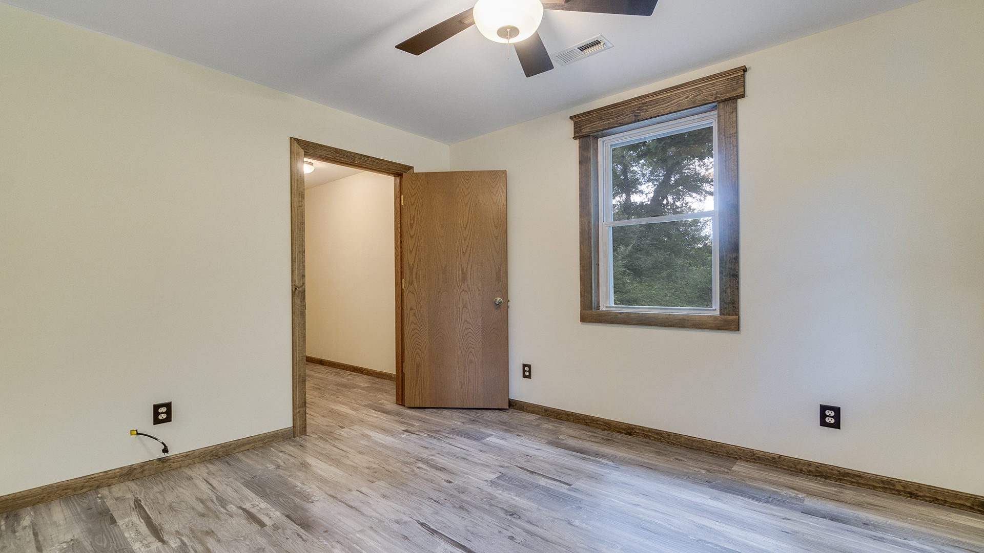 503 West Devils Backbone Road Oregon, IL 61061 - Photo 36 of 46 an empty room with wooden floor chandelier fan and windows