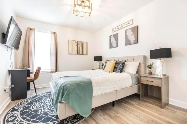 a bedroom with a bed and wooden floor