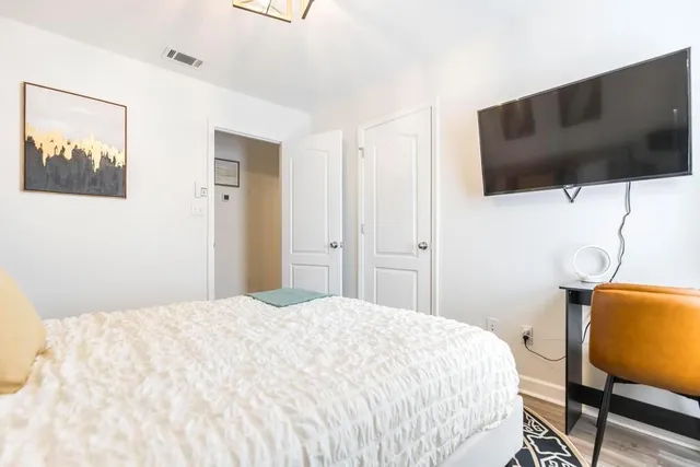 a bedroom with a bed tv and chair