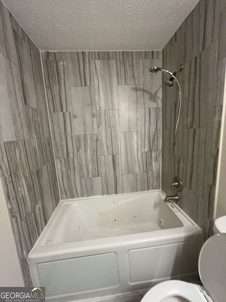 1265 Herrington Road Lawrenceville, GA 30044 - Photo 23 of 52 a bathroom with a bathtub and shower